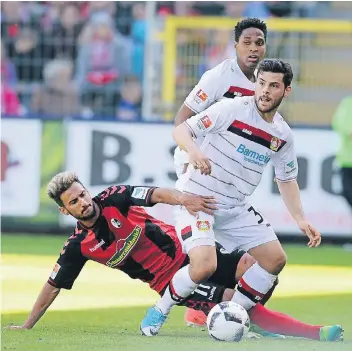  ?? FOTO: DPA ?? Kevin Volland (r.) – hier im Zweikampf Onur Bulut (l.) – und Bayer 04 ließen sich im Schwarzwal­d-Stadion in Freiburg von den Hausherren den Schneid abkaufen. Auch Wendell (hinten) schaute oft nur zu.