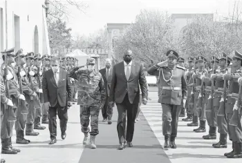  ?? PRESIDENTI­AL PALACE ?? Defense Secretary Lloyd Austin, center, walks with Afghan officials as they review an honor guard Sunday in Kabul, Afghanista­n. Austin arrived in Kabul amid swirling questions about how long U.S. troops will remain in the country.