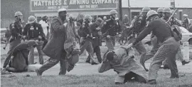  ?? AP ?? On March 7, 1965, a state trooper swings a billy club at John Lewis, right foreground, chairman of the Student Nonviolent Coordinati­ng Committee, to break up a civil rights voting march in Selma, Ala. Lewis sustained a fractured skull. Lewis died Friday at age 80.