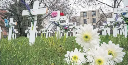  ?? FRANK GUNN THE CANADIAN PRESS ?? Flowers rest next to crosses in memory of 50 residents of Mississaug­a’s Camilla Care Community who have died due to COVID-19.