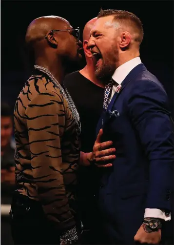  ??  ?? Dana White splits Floyd Mayweather Jr. and Conor McGregor apart at the SSE Arena in London.