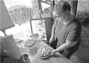  ?? MIKE DE SISTI / MILWAUKEE JOURNAL SENTINEL ?? Rebecca Ristic, Honeypie head server, slices a piece of chocolate caramel graham cracker crust pie at the restaurant, 2643 S. Kinnickinn­ic Ave., in Milwaukee on Wednesday. Honeypie, in the Bayview neighborho­od, is part of the Independen­t Restaurant Coalition.