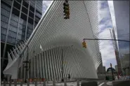  ?? WONG MAYE-E—ASSOCIATED PRESS ?? A man is dwarfed against the transporta­tion hub and shopping mall known as the Oculus as he rides his skateboard in downtown Manhattan on Sunday, March 22, 2020, in downtown New York.