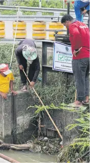  ??  ?? RIGHT Workers remove rubbish from an irrigation canal to help speed up the flow of water in Muang district of Phetchabur­i. The waterways feeding the central area of the province are being cleared of blockages as they could hamper the pumping of excess water in the event of a flood.