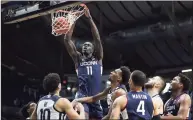  ?? Jenna Watson / Associated Press ?? UConn’s Akok Akok (11) dunks against Butler on Saturday in Indianapol­is, his first action since suffering an Achilles’ tendon injury last year.