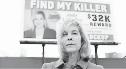  ?? JEN RYNDA / BALTIMORE SUN MEDIA GROUP ?? Jennifer LeCornu Carrieri stands in front of a billboard advertisin­g for informatio­n about the unsolved murder of her twin sister, Joann “Jody” LeCornu, 22 years ago in Towson. Carrieri paid for the billboard, which was unveiled Monday, a day after the twins’ birthday.