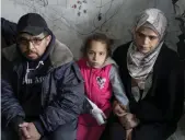  ?? Reuters ?? Palestinia­n girl Jamila Khelah — who survived an airstrike in the Gaza Strip, that injured her and killed three of her siblings — sits between her parents at a shelter for displaced people in Jabalia.