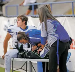  ??  ?? St. Michael’s quarterbac­k Lucas Coriz, right, watches Friday’s game from the sidelines after suffering a leg injury during the first quarter. Coriz will likely be out for the rest of the season.