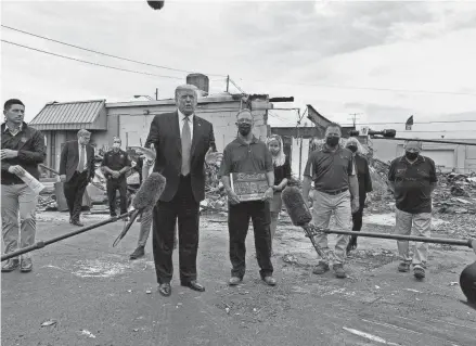  ?? MOLLY BECK / MILWAUKEE JOURNAL SENTINEL ?? President Donald Trump meets with an owner of B&L Office Furniture in Kenosha on Tuesday. The business was burned down last week during unrest following the police shooting of Jacob Blake.