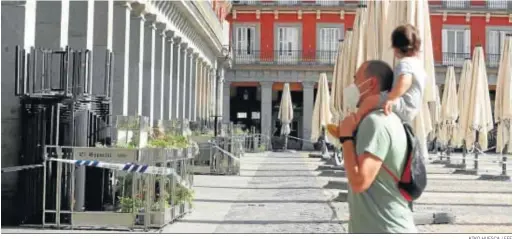  ?? KIKO HUESCA / EFE ?? Un viandante y su hijo pasean ayer por la Plaza Mayor de Madrid.