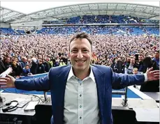  ?? MIRROR ?? SEJARAH: Tony Bloom berfoto dengan latar belakang euforia suporter Brighton merayakan sukses timnya meraih tiket promosi ke Premier League.