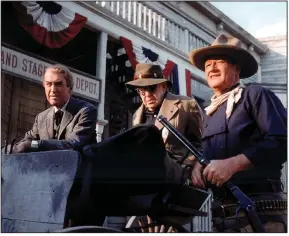  ??  ?? John Wayne (right) takes five behind the scenes with Jimmy Stewart and director John Ford on the set of “The Man Who Shot Liberty Valance” (1962).