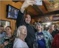  ?? MARK PYNES — THE PATRIOT-NEWS VIA AP ?? John Fetterman takes a selfie with voters while he campaigns for U.S. Senate at the Holy Hound Tap Room in downtown York, Pa., Thursday, May. 12, 2022.