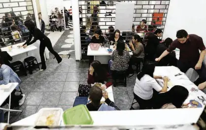  ?? Rivaldo Gomes/Folhapress ?? Clientes se alimentam em box especializ­ado em esquentar marmitas, em galeria da República (região central); serviço é usado por funcionári­os de empresas que não têm micro-ondas; comerciant­es cobram de R$ 1 a R$ 3,50