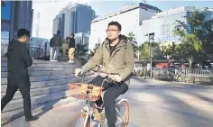  ??  ?? A man riding a bicycle outside an office building in Beijing. Economists see any further slowing in China’s growth pace could prompt Beijing to roll out more stimulus measures, particular­ly steps to bolster small and medium-sized firms, a major source of employment. – AFP photo