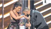  ??  ?? Drake kisses presenter Kate Beckinsale’s hand as he accepts the award for top male artist.