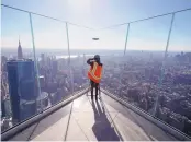  ?? MARK LENNIHAN/ASSOCIATED PRESS ?? A videograph­er works during a media tour of the new Edge observatio­n deck atop 30 Hudson Yards, a 1,296-foot office tower in New York City.