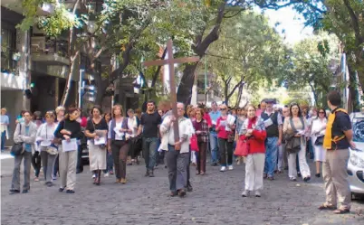  ?? FLORENCIA URIBURU ?? Unidos por la fe en Cristo. Fieles de diversas confesione­s cristianas caminan con la cruz por las calles del barrio de Belgrano.