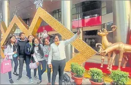  ??  ?? Youngsters taking a selfie in front of a decked up mall in Lucknow on Wednesday. (Below) Christmas cakes on display at a bakery shop in the state capital.