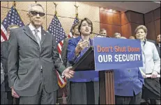  ?? ASSOCIATED PRESS ?? Sen. Amy Klobuchar (center), D-Minn., with Senate Minority Leader Harry Reid (left), D-Nev., and other Democratic lawmakers on Capitol Hill, talks about the urgency of funding Homeland Security.