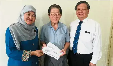  ??  ?? Prompt
action: Nor Inchun handing over two cheques to Lim at his home in Ara Damansara. Looking on is PSD Post Service Division director Teo Khian How.