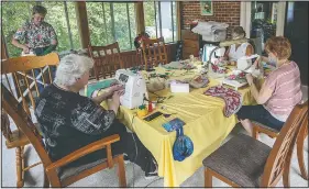  ?? (Herald & Review/Clay Jackson) ?? Karen Goloff (left) works with a group of women to create Christmas stockings at a home in Decatur, Ill. The holiday decoration­s and other donations will be packaged and sent through Operation Enduring Support to military members currently deployed.