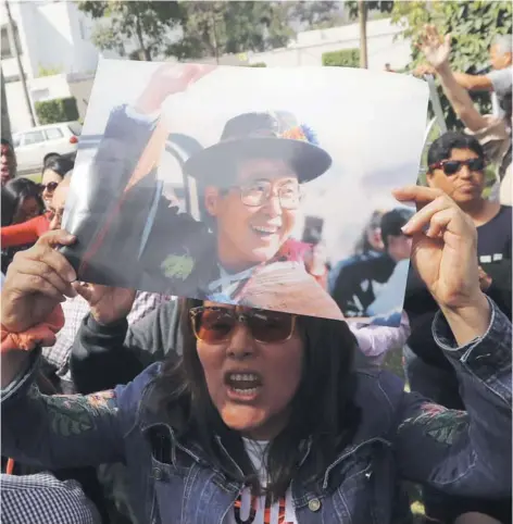  ??  ?? ► Una partidaria de Alberto Fujimori se manifiesta ayer frente a la casa del expresiden­te en Lima.