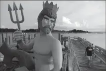  ?? CHIP SOMODEVILL­A/GETTY IMAGES ?? A statue in the likeness of Poseidon, the Greek god of the oceans, stands along the boardwalk on Sept. 12, 2018, in Morehead City, N.C.