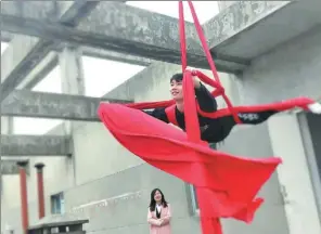  ?? PHOTOS PROVIDED TO CHINA DAILY ?? Wang Wenbin dances on a rope on the roof of a building in Jiaxing, Zhejiang province,