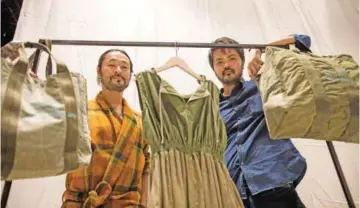  ??  ?? Japanese Lequio fashion brand’s designer Hiloki Deliva (left) and director Yoshinari Kakazu (right) pose next to creations of their Okinawa-based brand in Tokyo.