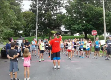  ?? MELISSA SCHUMAN - MEDIA NEWS GROUP ?? Glenn Wolin, owner of Finish Right Timing, gets the 10-mile racers ready to go.