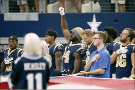  ?? RON JENKINS — THE ASSOCIATED PRESS FILE ?? In this file photo, then-Los Angeles Rams linebacker Robert Quinn (94) raises his fist during the playing of the national anthem before an NFL football game against the Dallas Cowboys, in Arlington, Texas. Dallas Cowboys defensive end Robert Quinn says the issue of protesting during the national anthem “might come up” before the season with owner Jerry Jones, who in the past has taken a hardline stance against displays by his players. Quinn joined the Cowboys in an offseason trade.