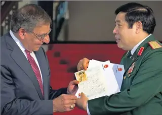  ?? Pool photo by Jim Watson ?? Personal effects: Vietnamese Defense Minister Phuong Quang Thanh presents letters of Sgt. Steve Flaherty, who was killed in 1969, to U.S. Defense Secretary Leon Panetta during a news conference Monday in Hanoi.