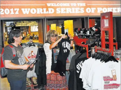  ?? Bizuayehu Tesfaye ?? A couple, who declined to give their names, shop for 2017 World Series of Poker T-shirts at the Rio gift shop on Friday.