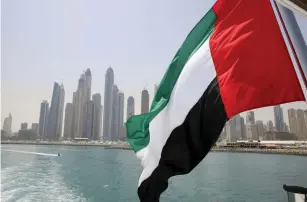  ?? (Ahmed Jadallah/Reuters) ?? UAE FLAG FLIES over a boat in the Dubai Marina.