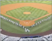  ?? THE ASSOCIATED PRESS ?? Members of the Los Angeles Dodgers and the San Francisco Giants kneel during a moment of silence prior to an opening day baseball game Thursday.