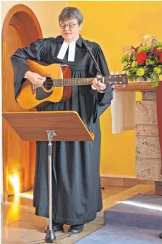  ?? FOTO: BAY ?? Ein vertrautes Bild: Pfarrerin Angelika Hofmann spielt Gitarre im Gottesdien­st.