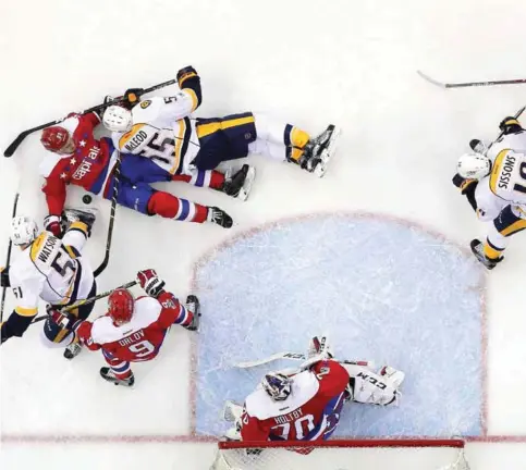  ??  ?? WASHINGTON DC: Kevin Shattenkir­k #22 of the Washington Capitals and Cody McLeod #55 of the Nashville Predators battle for the puck during the second period at Verizon Center. — AFP