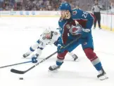  ?? MATTHEW STOCKMAN/GETTY ?? Avalanche star Nathan MacKinnon (29) carries the puck in front of Lightning center Anthony Cirelli during Game 1 on Wednesday.