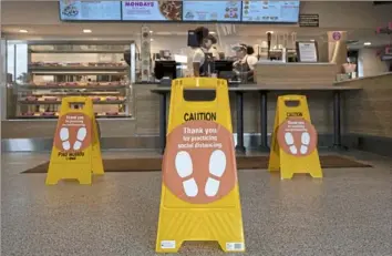  ?? Lily LaRegina/Post-Gazette ?? Caution signs mark socially distanced lines for customers at the newly opened Dunkin’ in Wilkins on Monday. Dunkin’ continues to open stores during the pandemic.
