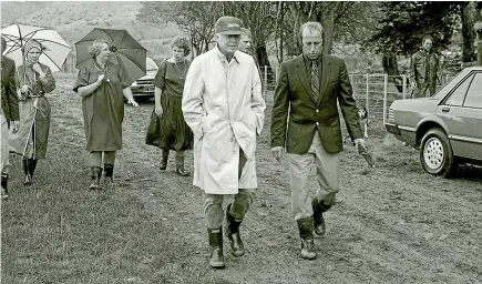  ?? MANAWATU¯ STANDARD ?? Strolling in the rain at the Walton farm in Aokautere, Rosalynn Carter with an umbrella, left rear, and Jimmy Carter, front, left.