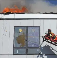  ?? STAFF PHOTO BY ANGELA ROWLINGS ?? ‘A LIFE OF ITS OWN’: Boston firefighte­rs try in vain to halt a fire that ripped through the sixstory constructi­on project yesterday.