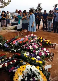  ?? (Ronen Zvulun/Reuters) ?? FAMILY AND FRIENDS mourn at the graves of Yosef, Chaya and Elad Salomon, who were buried at the Modi’in Cemetery, on July 23.