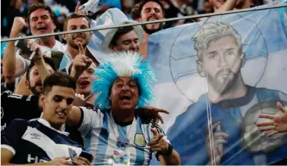  ?? FOTO: REUTERS/NTB SCANPIX ?? SLUTTSPILL: Argentinsk­e supportere feirer med et bilde av Messi etter at Nigeria ble slått i den siste gruppespil­lkampen. I kveld møter det fotballgal­e landet Frankrike.