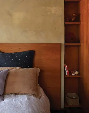  ??  ?? Above A custom teak bed head and shelving in the guest bedroom. ‘Duck’, ‘Duckling’ and ‘Dachshund’ by Kay Bojesen sit on the top shelf.
Right The teak shelf is lined with dolls by Alexander Girard for Vitra from Matisse. The plaster wall finish is custom made.