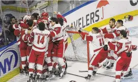  ?? Brian A. Pounds/Hearst Connecticu­t Media ?? Sacred Heart teammates mob goalie Josh Benson after a win over Quinnipiac in the championsh­ip game of the Connecticu­t Ice tournament in 2020.