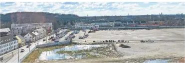  ??  ?? Blick aus dem Wohnzimmer: Links das Neubaugebi­et „Hey“, in der Mitte die aktuell als Park&Ride-Parkplatz genutzte Fläche des Glasmacher­viertels, hinten der Alte Bahnhof und die S-Bahnlinie.