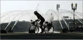  ?? DON RYAN — THE ASSOCIATED PRESS ?? A bicyclists heads through downtown past the Salmon Street Springs fountain in Portland, Ore., Wednesday. Scorching temperatur­es are predicted for the Northwest Wednesday and Thursday, with forecaster­s saying Seattle and Portland could top triple...