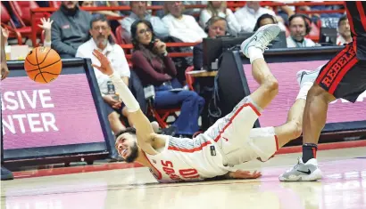  ?? PHOTOS BY ERIC DRAPER/THE ASSOCIATED PRESS ?? UNM guard Jaelen House hits the floor while losing control of the ball against UNLV on Saturday in The Pit in Albuquerqu­e. UNLV won 80-77. House scored 20 points against the Rebels.