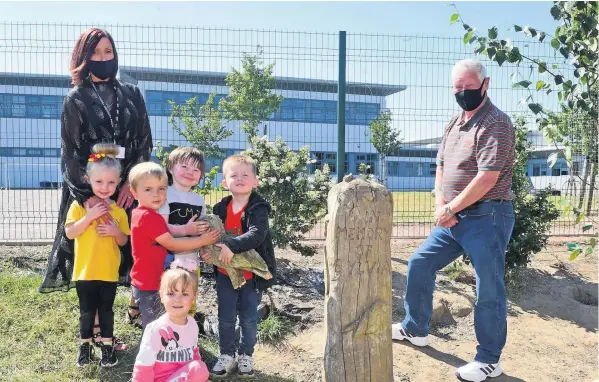  ??  ?? Disgusted Councillor Ian Cavana and Jackie Kelly Centre Manager and childrfen at a wood carved memorial to Sylvia Brown that had the owl broken off the top.